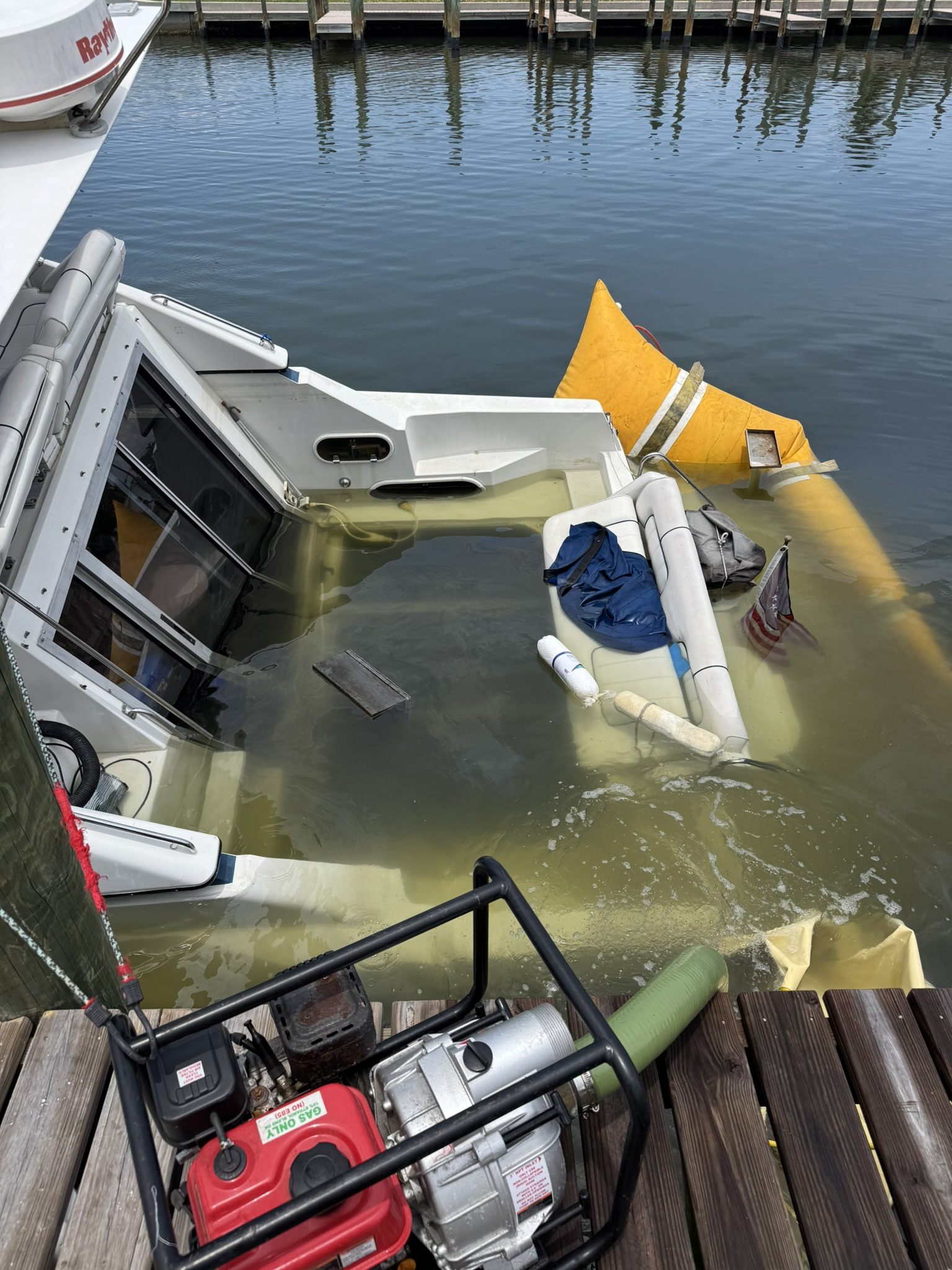 Cabin cruiser showing water intrusion and recovery equipment at the dock